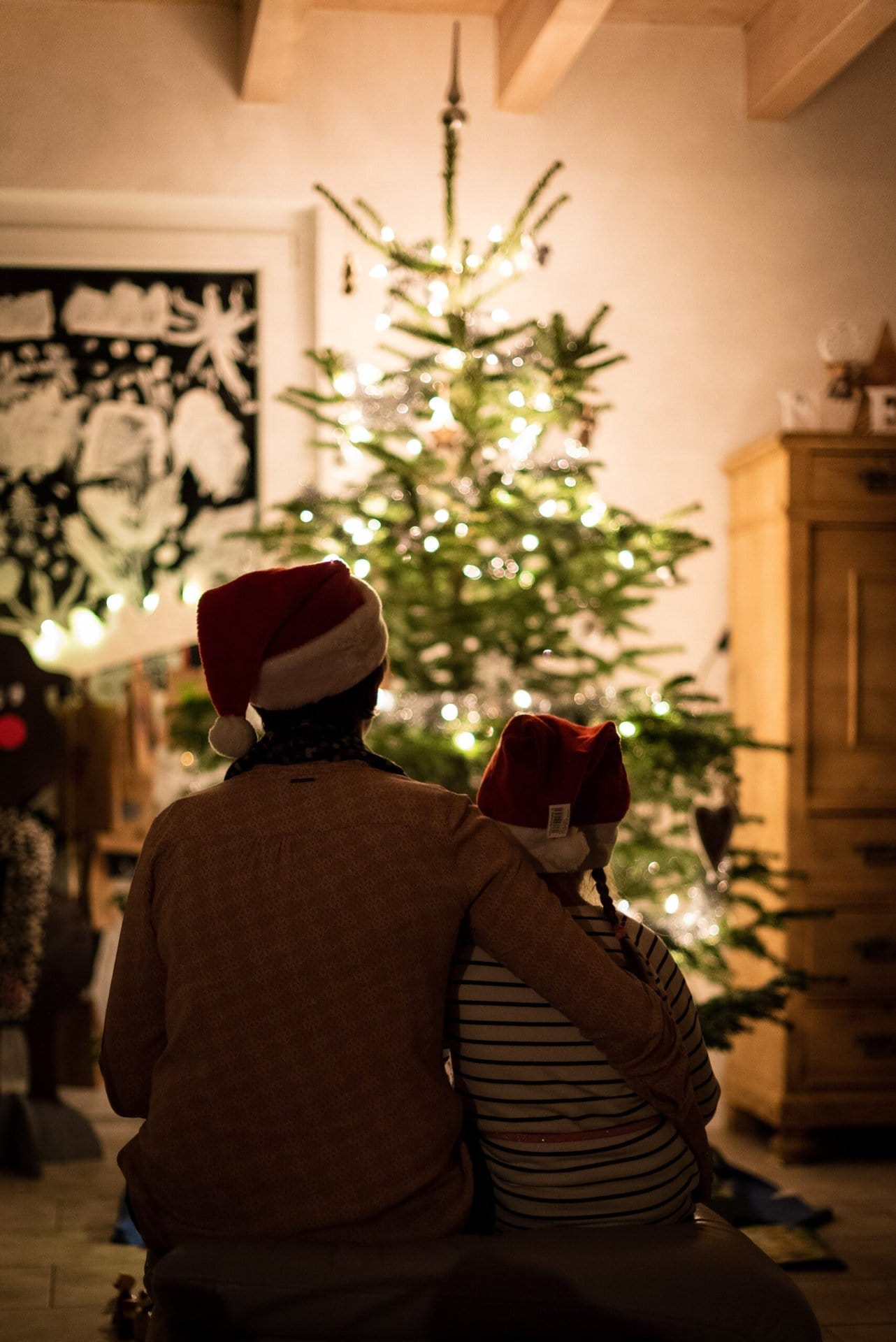 kunstiline-weihnachten-geschwister selective focus photography of girl an woman hugging each other in front of christmas tree